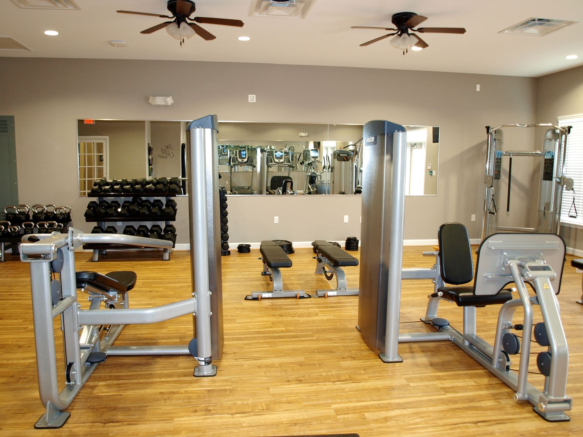 A gym with a lot of equipment and a large mirror
