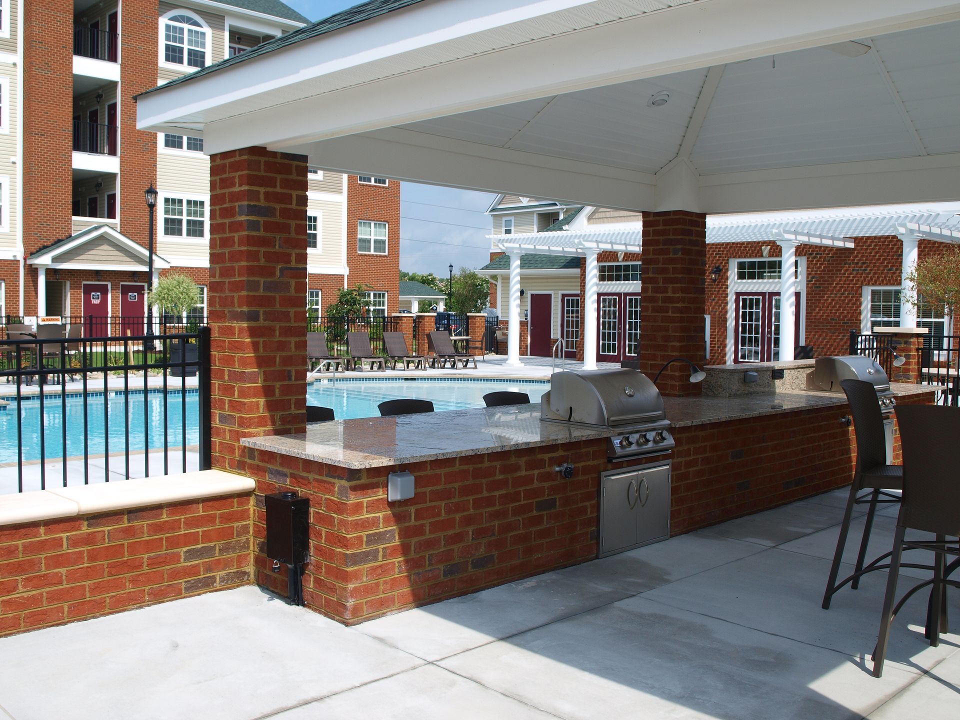 A large brick building with a swimming pool in the background