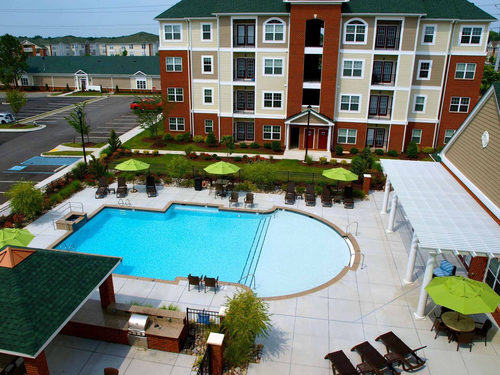 A large apartment building with a large swimming pool in front of it