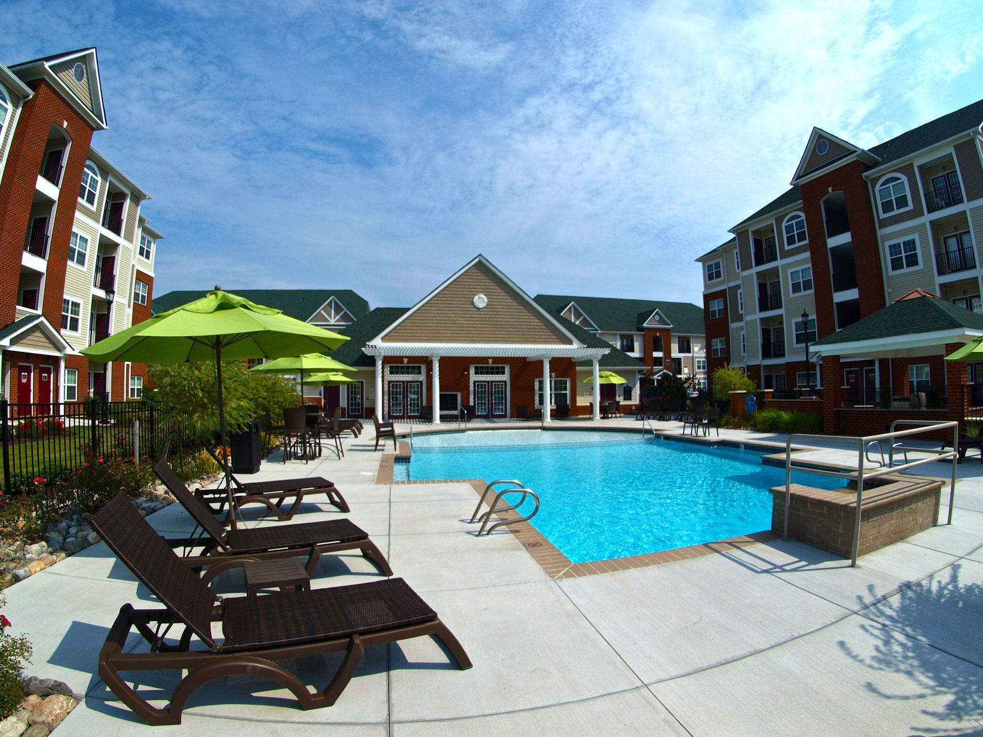 A large swimming pool surrounded by chairs and umbrellas