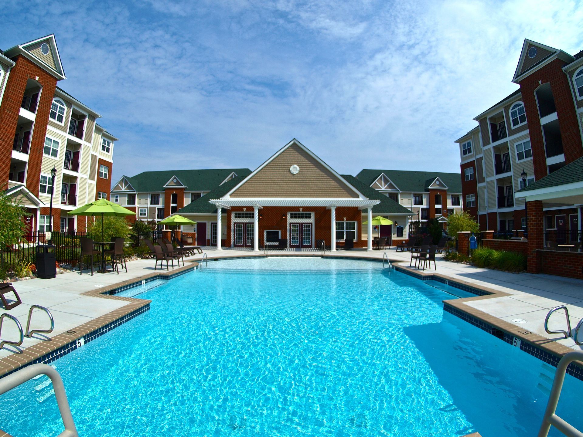 A large swimming pool in front of a large apartment building