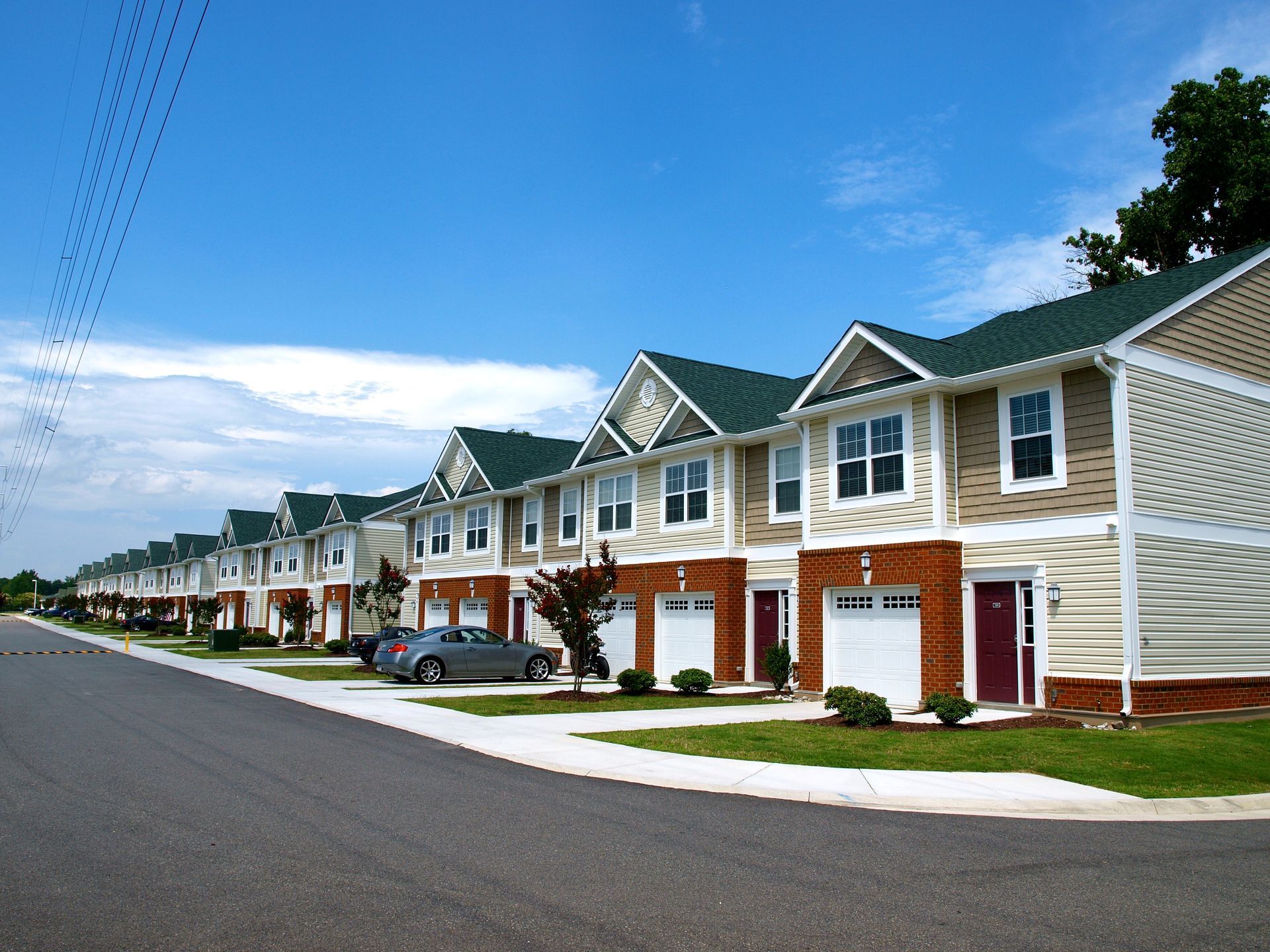 A row of houses with cars parked in front of them