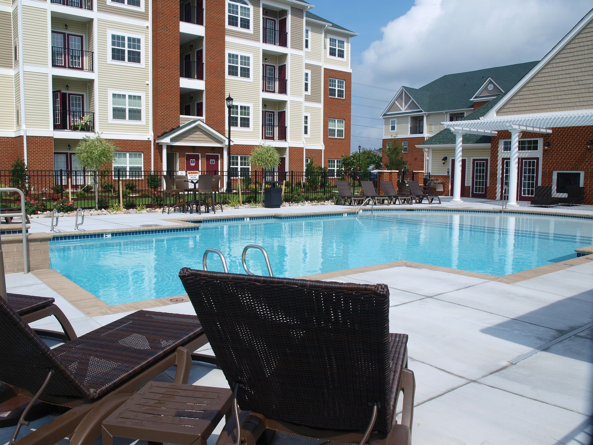 A large swimming pool in front of a brick building