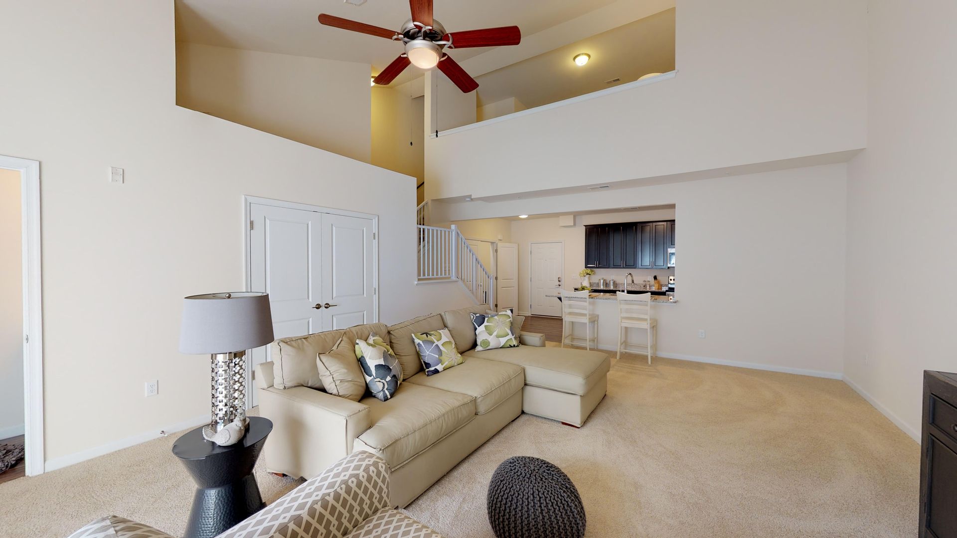 A living room with a couch and a ceiling fan.