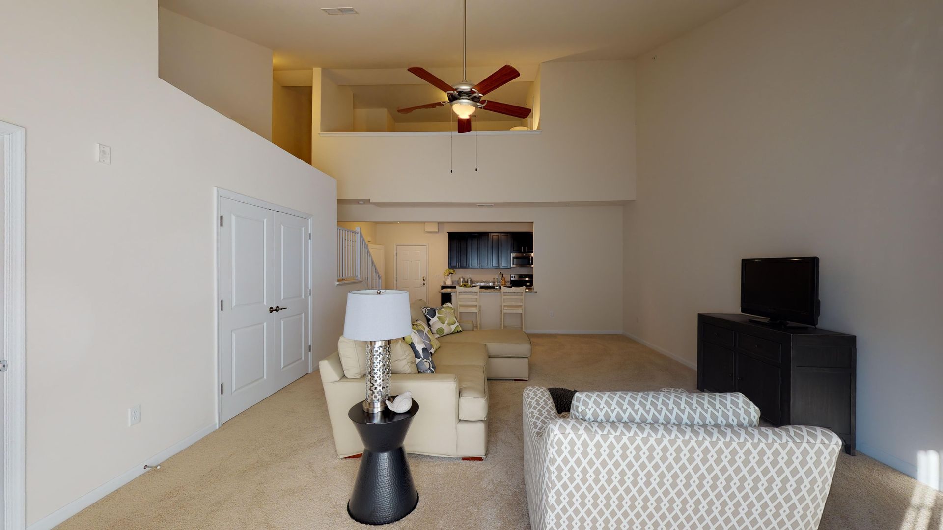A living room with a ceiling fan and two chairs