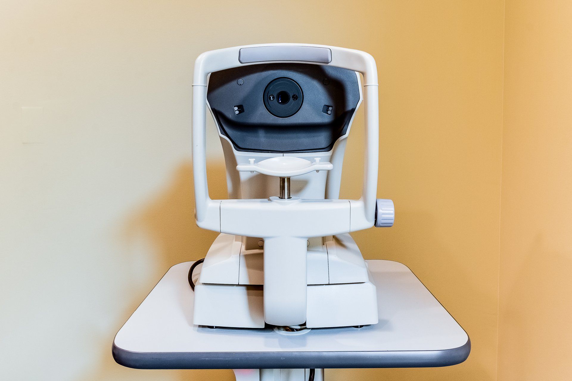 An eye examination machine is sitting on a table in a room.