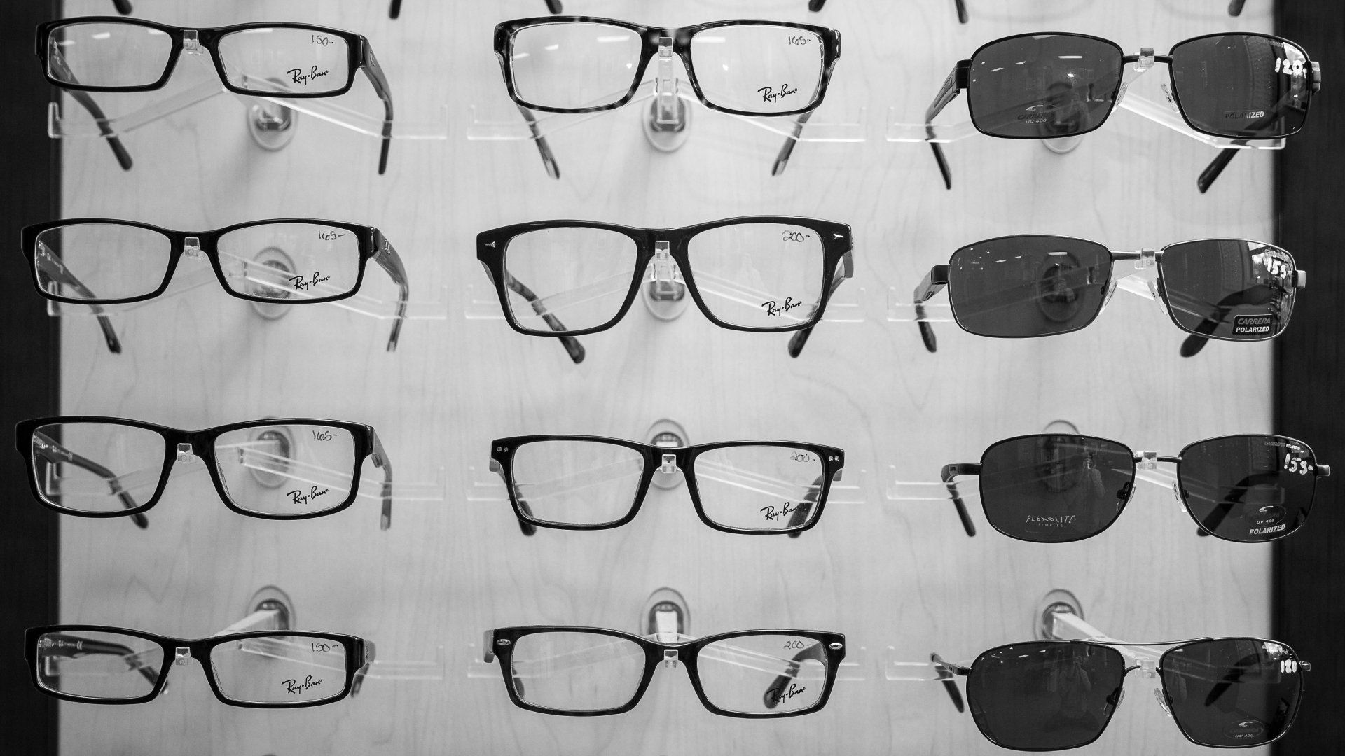 A black and white photo of glasses and sunglasses on display