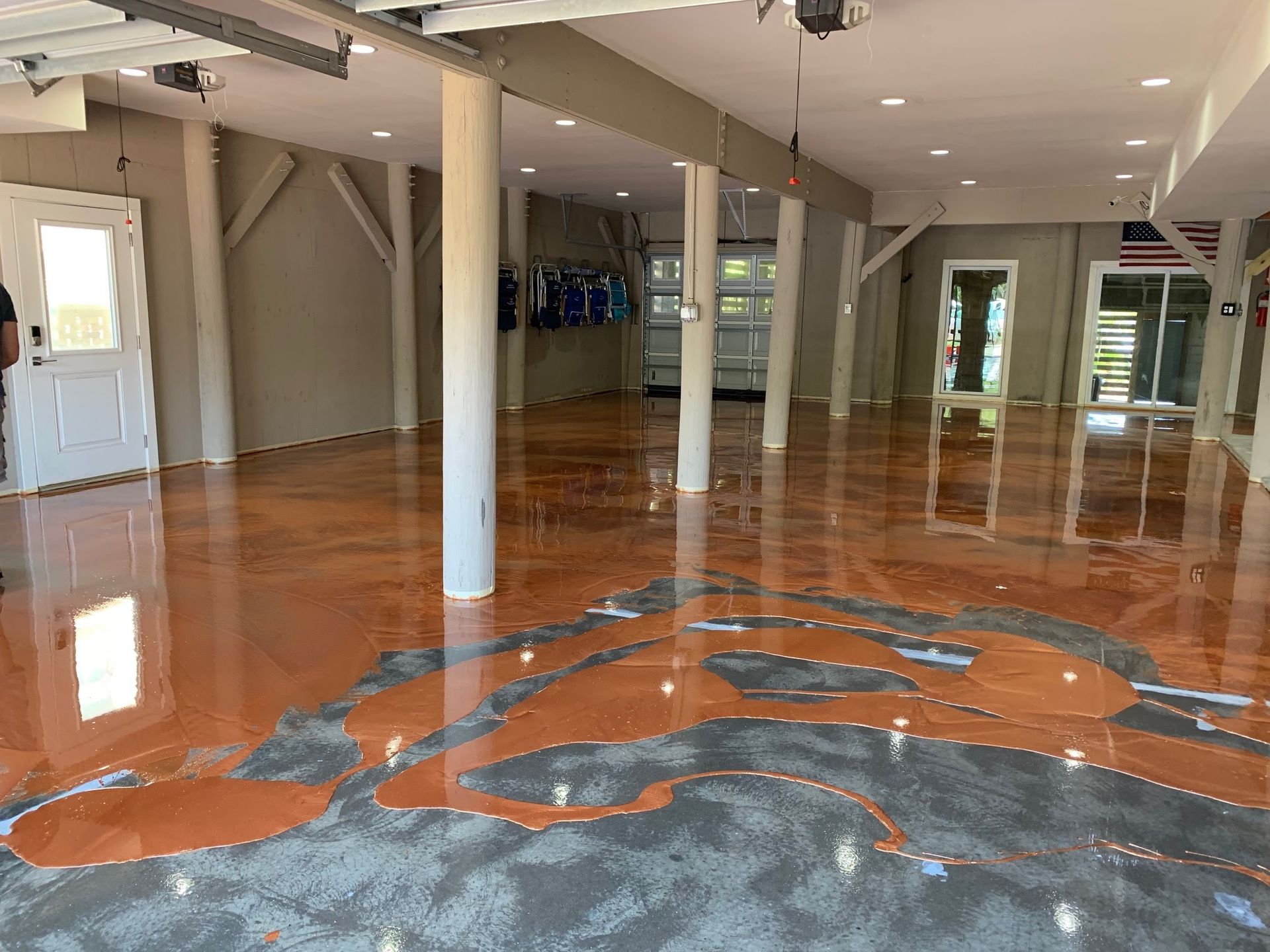 Empty room with glossy orange-and-gray patterned floor and white support columns