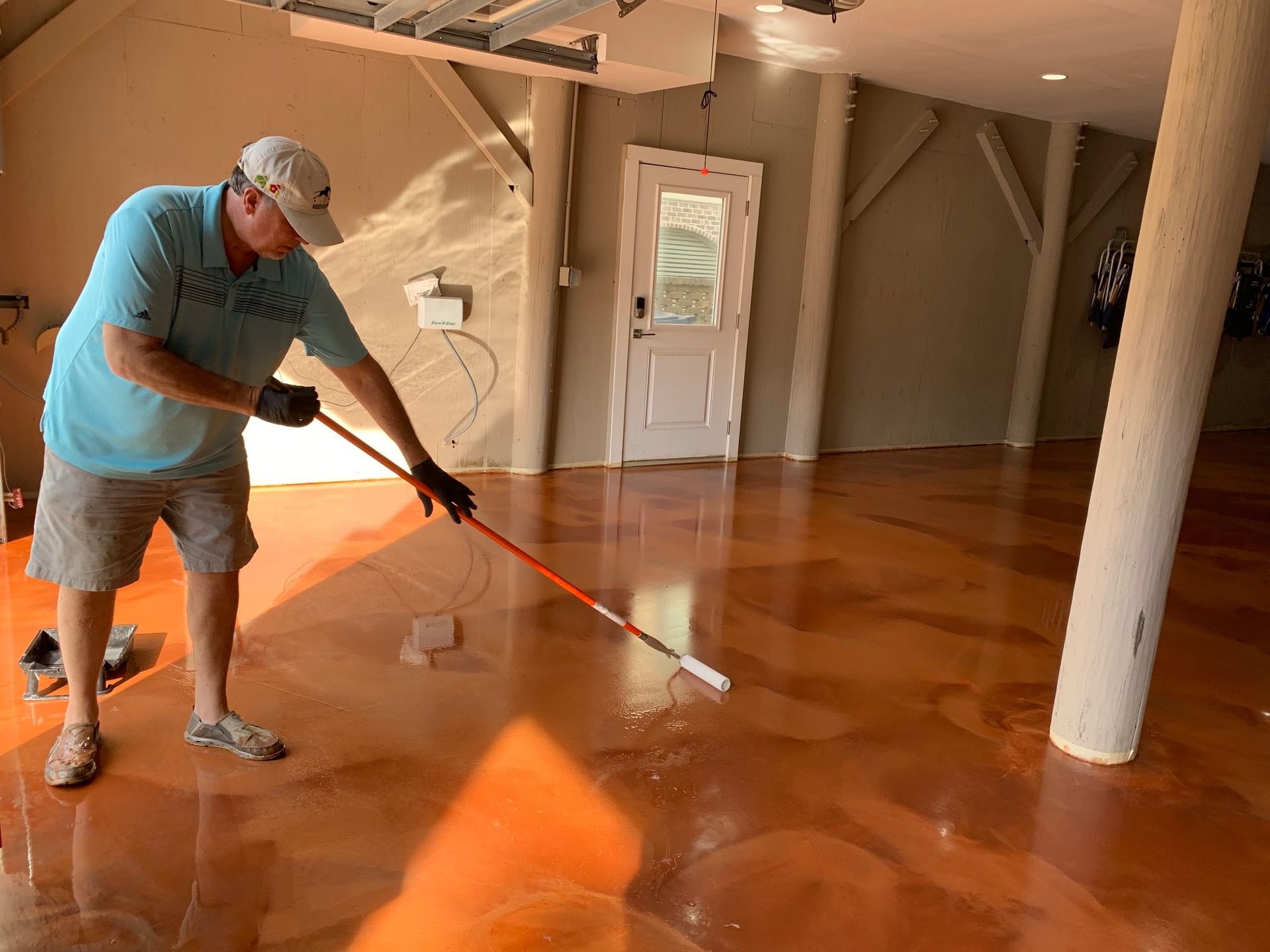 Person mopping a glossy wooden floor inside a sunlit room.