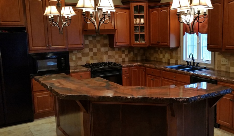 Wooden kitchen with dark cabinets, granite island, hanging lights, and a window over the sink
