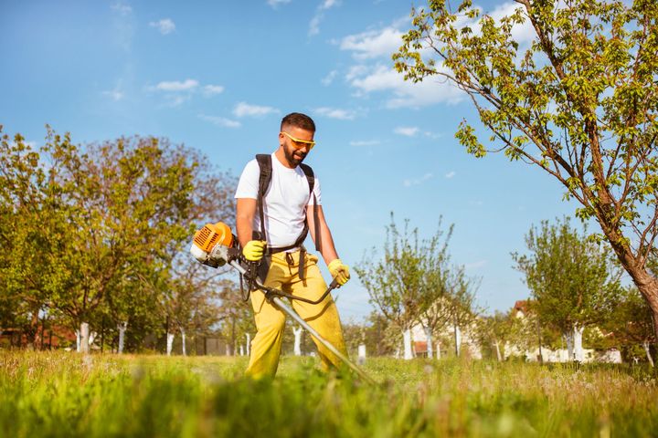 A Man Mows The Thick Grass With A Gasoline Trimmer – Salem County – Yurgin's Lawn Care