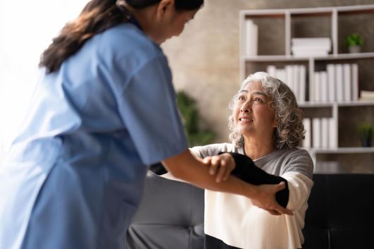 Nurse holding hand of senior woman in pension home