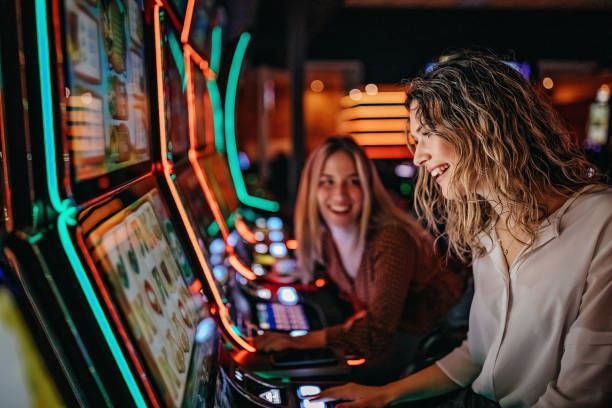 Two women are playing a slot machine - Jacksonville, NC - Music Vendors Inc