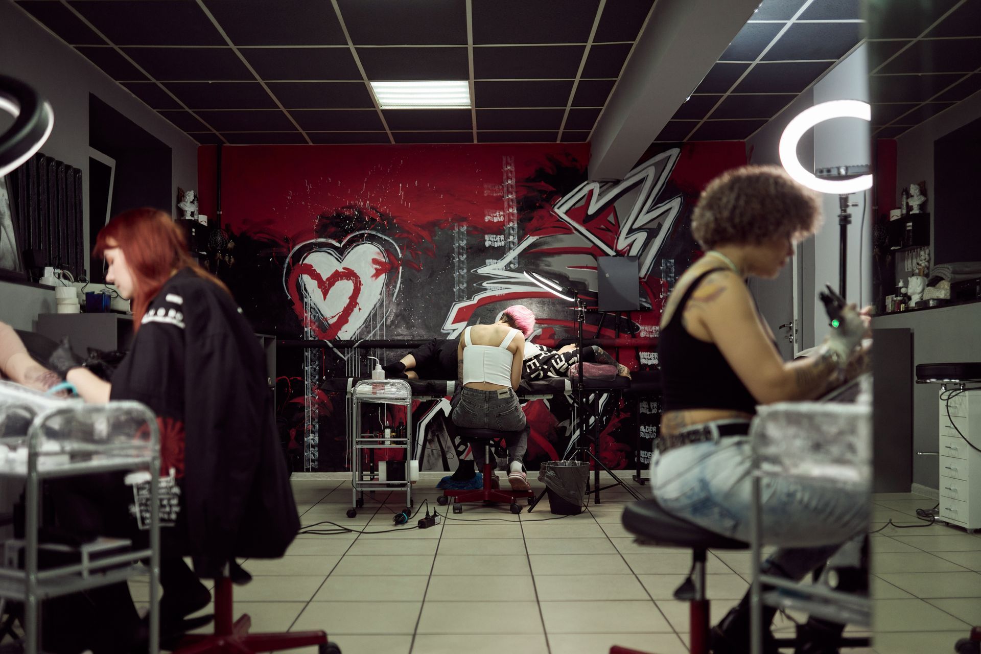 A woman is getting a tattoo in a tattoo shop.