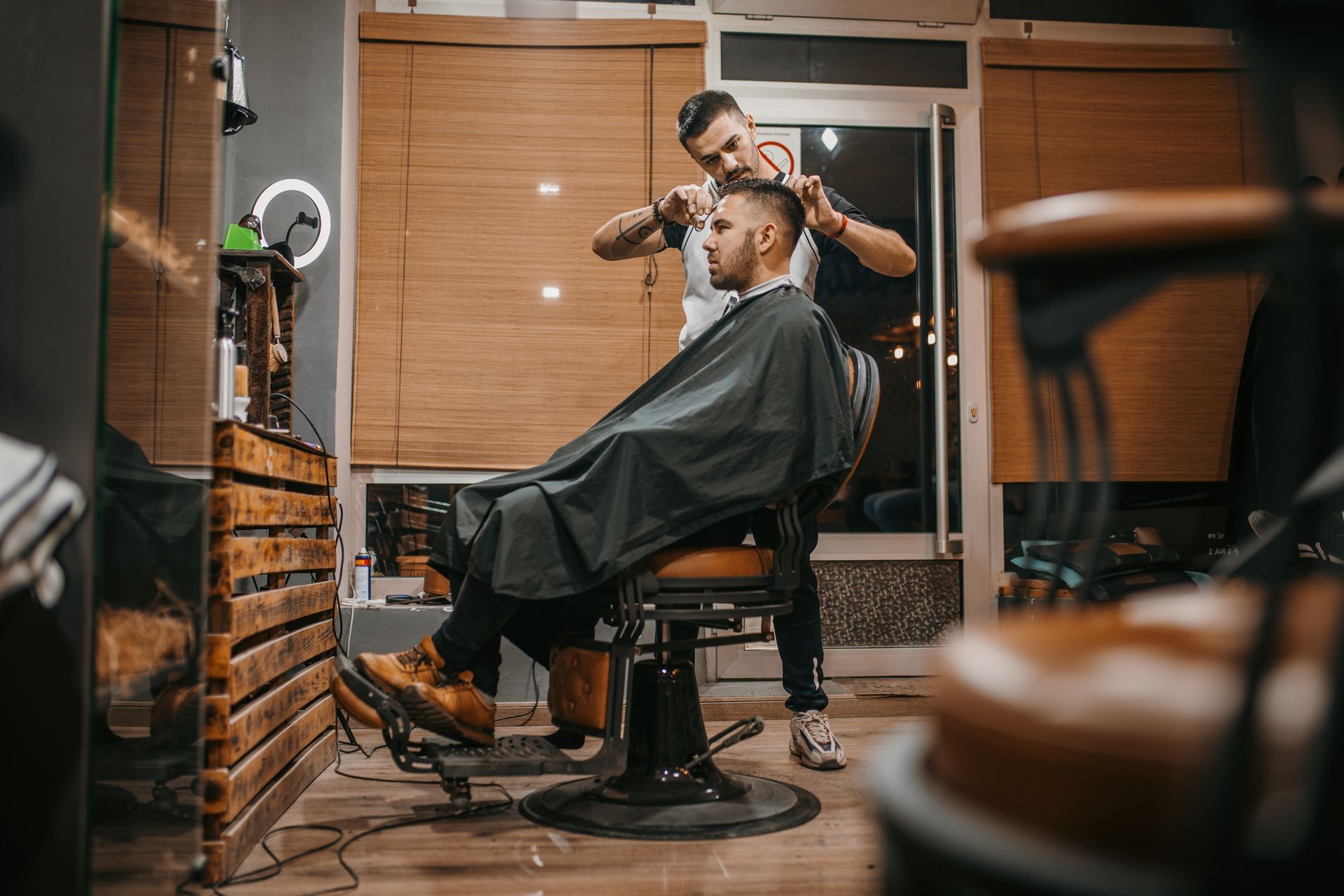 A man is getting his hair cut by a barber in a barber shop.