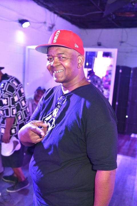 A group of people are posing for a picture in a parking lot.
