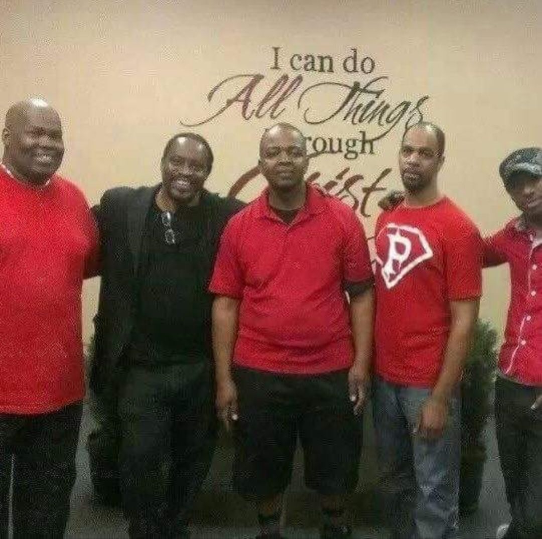 A group of men standing in front of a wall that says i can do all things through christ
