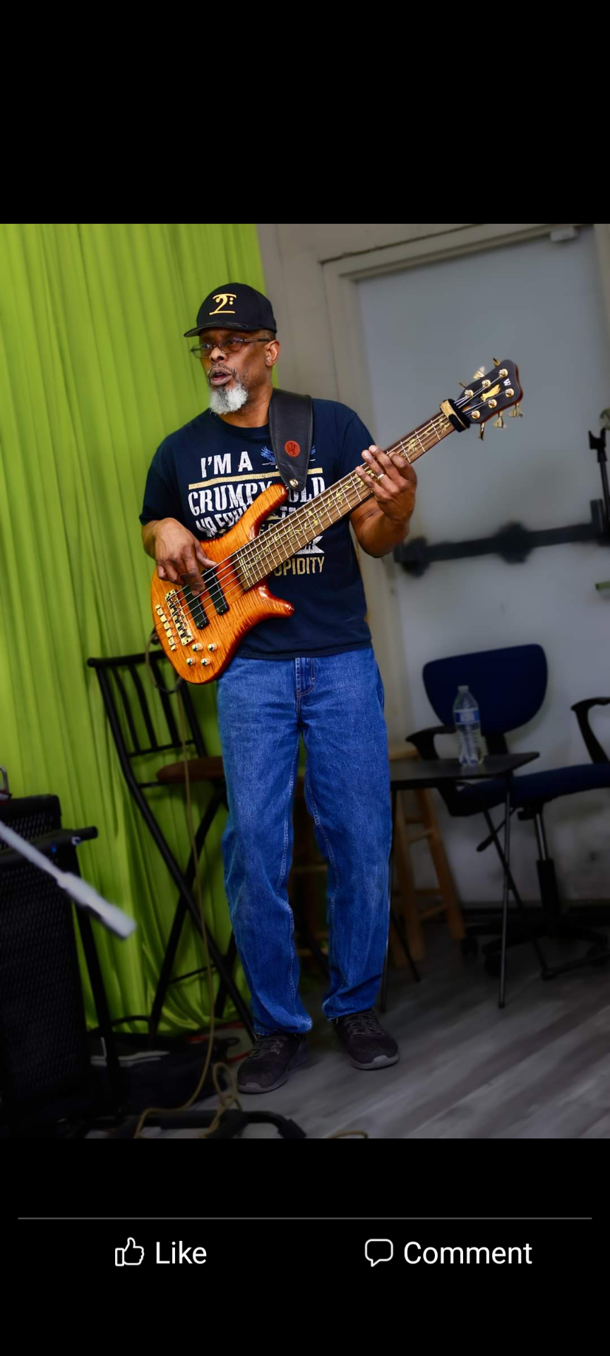 A man is playing a guitar in a room.