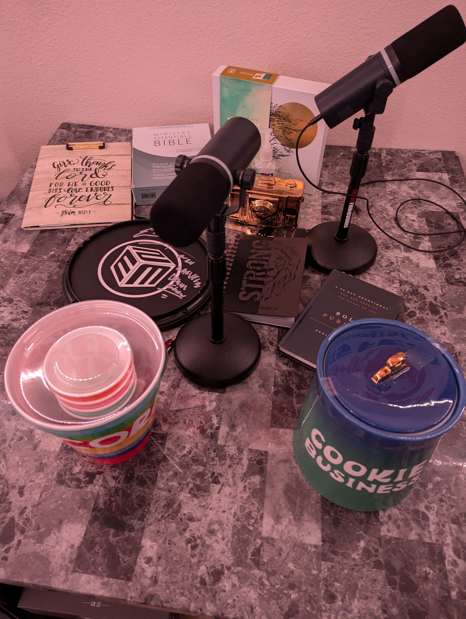 A table with two microphones and a cup that says cookie business