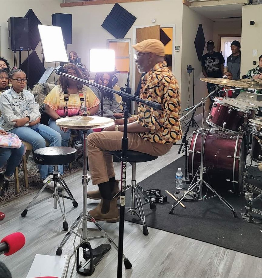 A man playing drums in front of a group of people