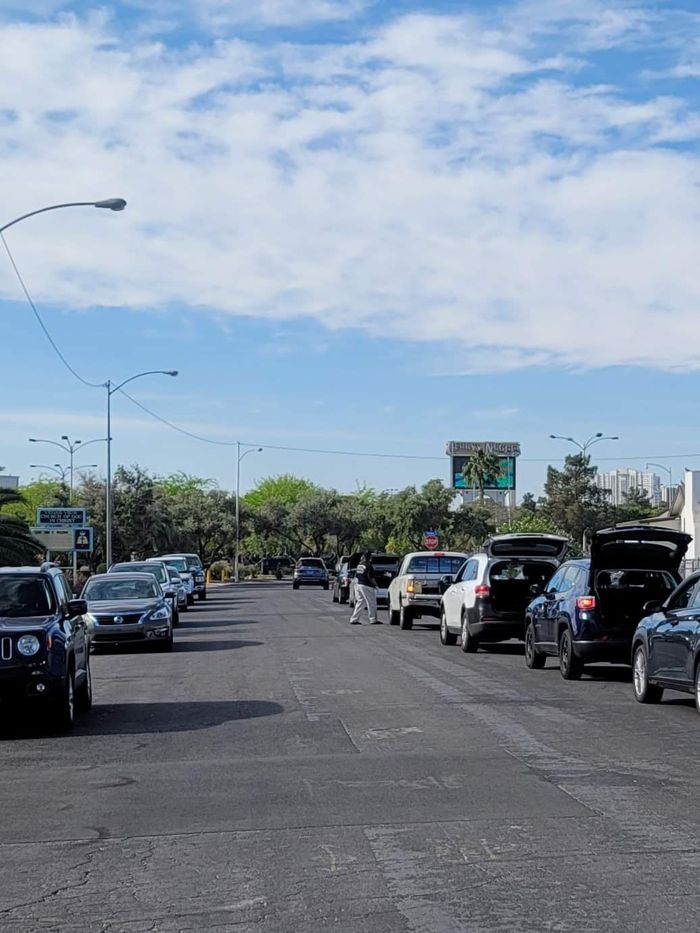 A row of cars are parked on the side of a street.