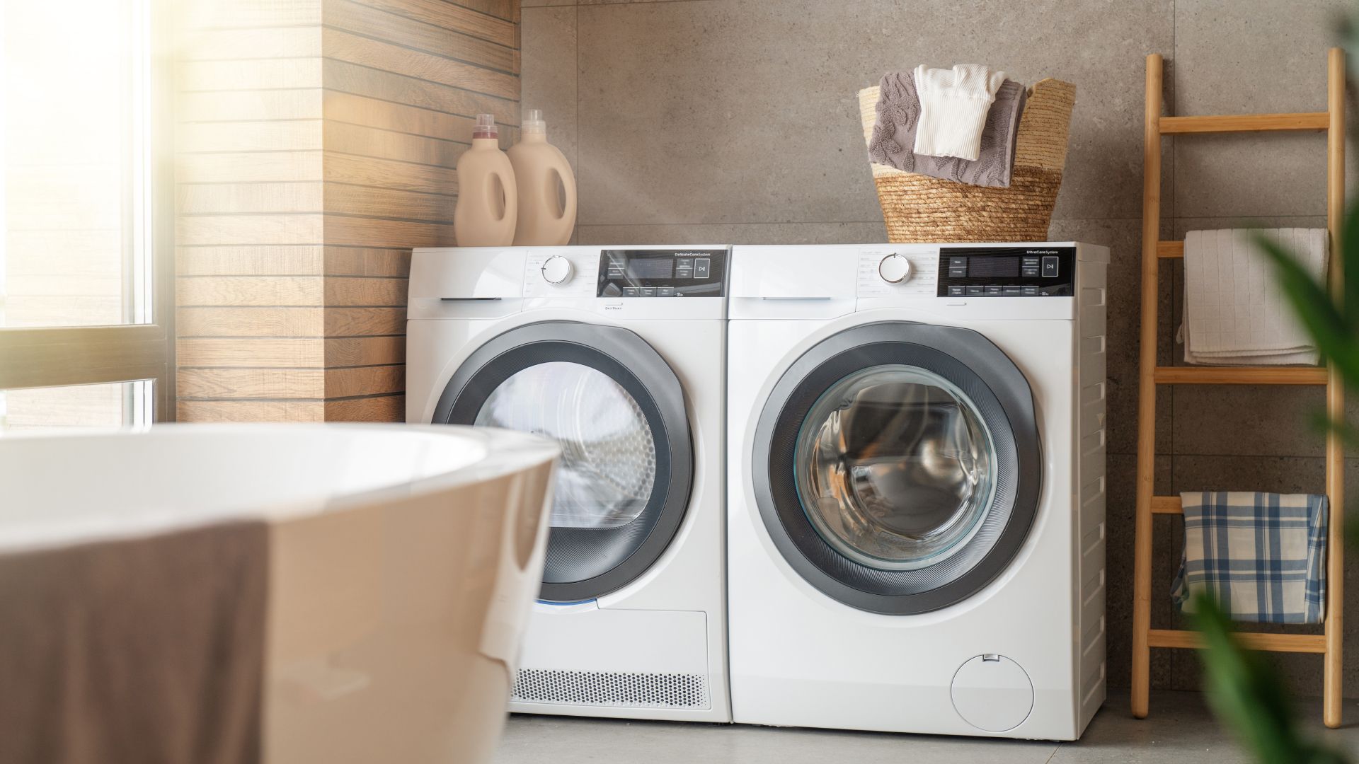 A bathroom with two washing machines and a bathtub.