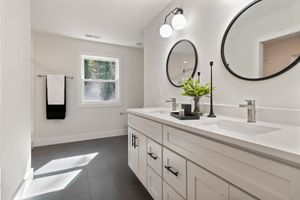 A bathroom with two sinks and two mirrors.