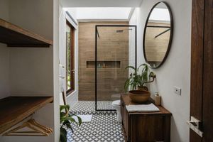 A bathroom with a sink , mirror and walk in shower.