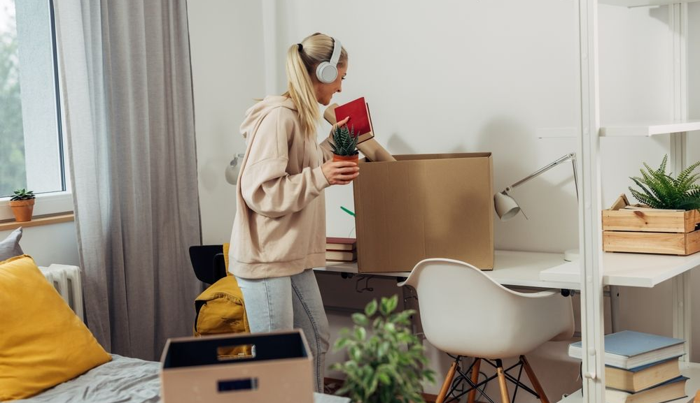 A college student is unpacking her stuff from boxes.