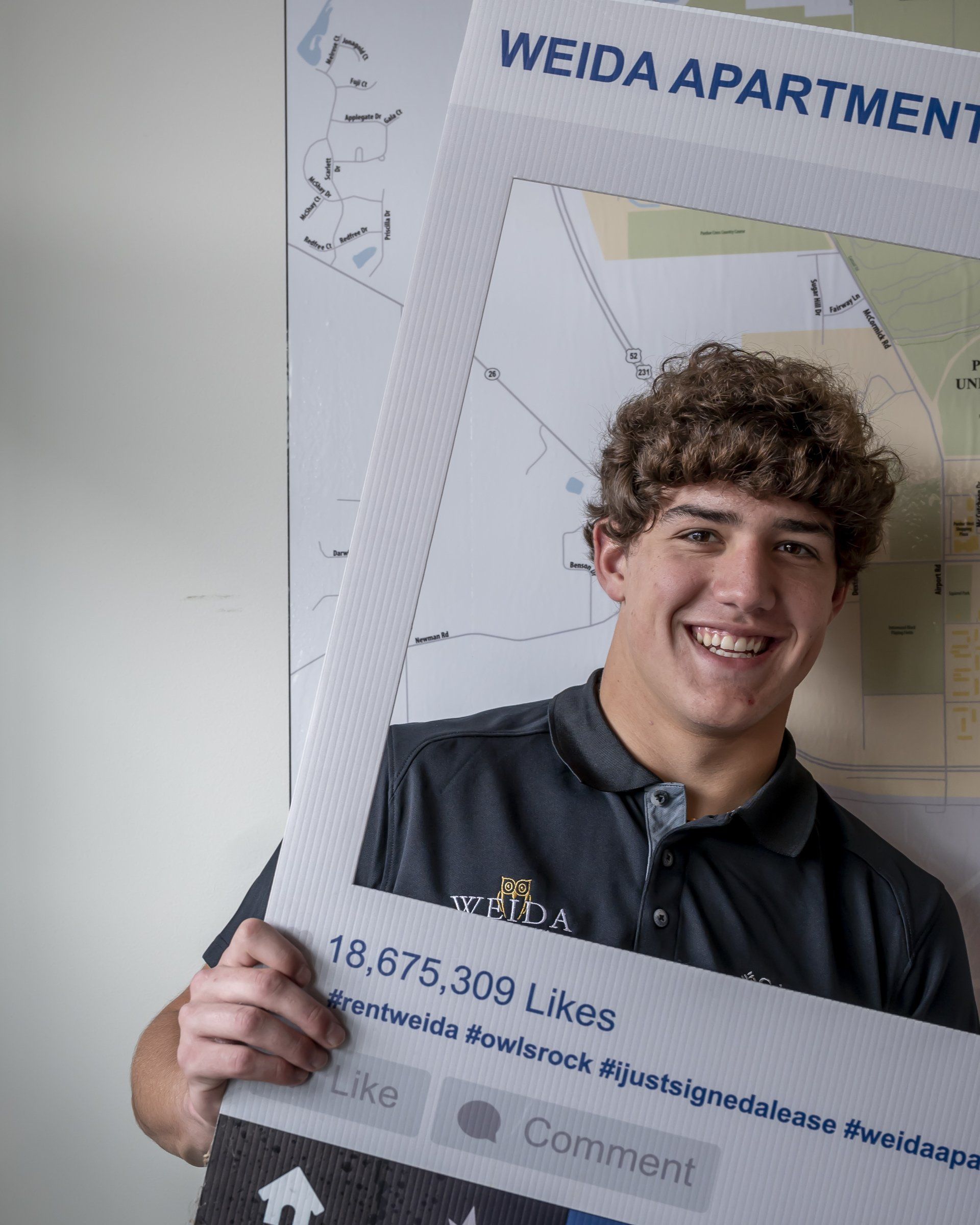 Weida staff member holding frame for photo - Weida Apartments