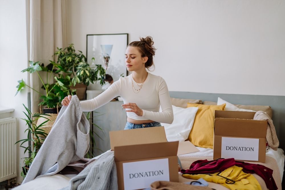 Young woman donating items to declutter her apartment.