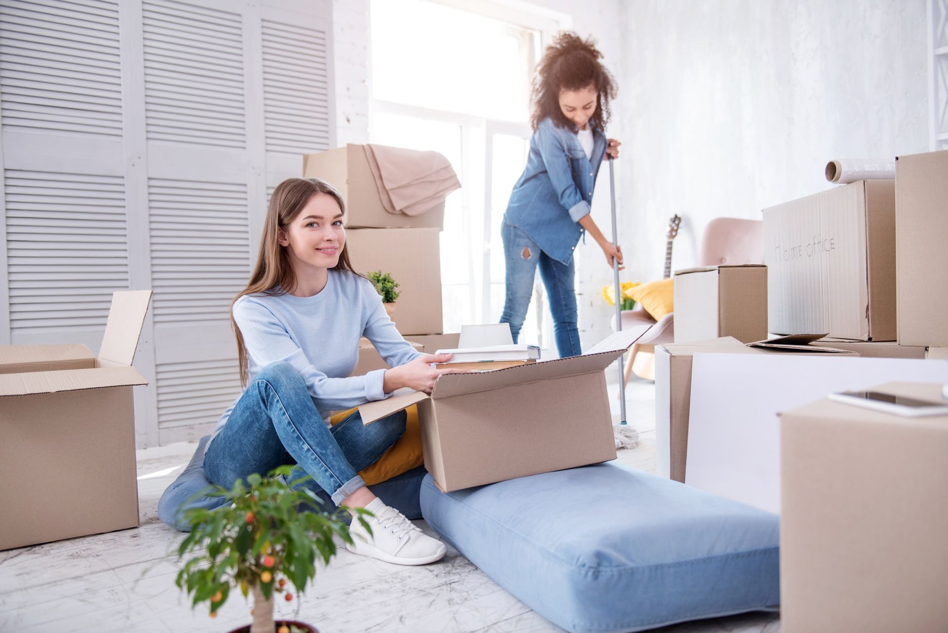 Two girls cleaning their apartment.