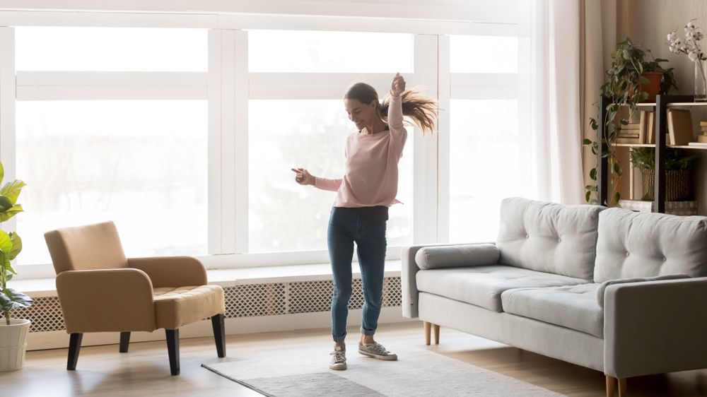 college girl dancing in her new apartment