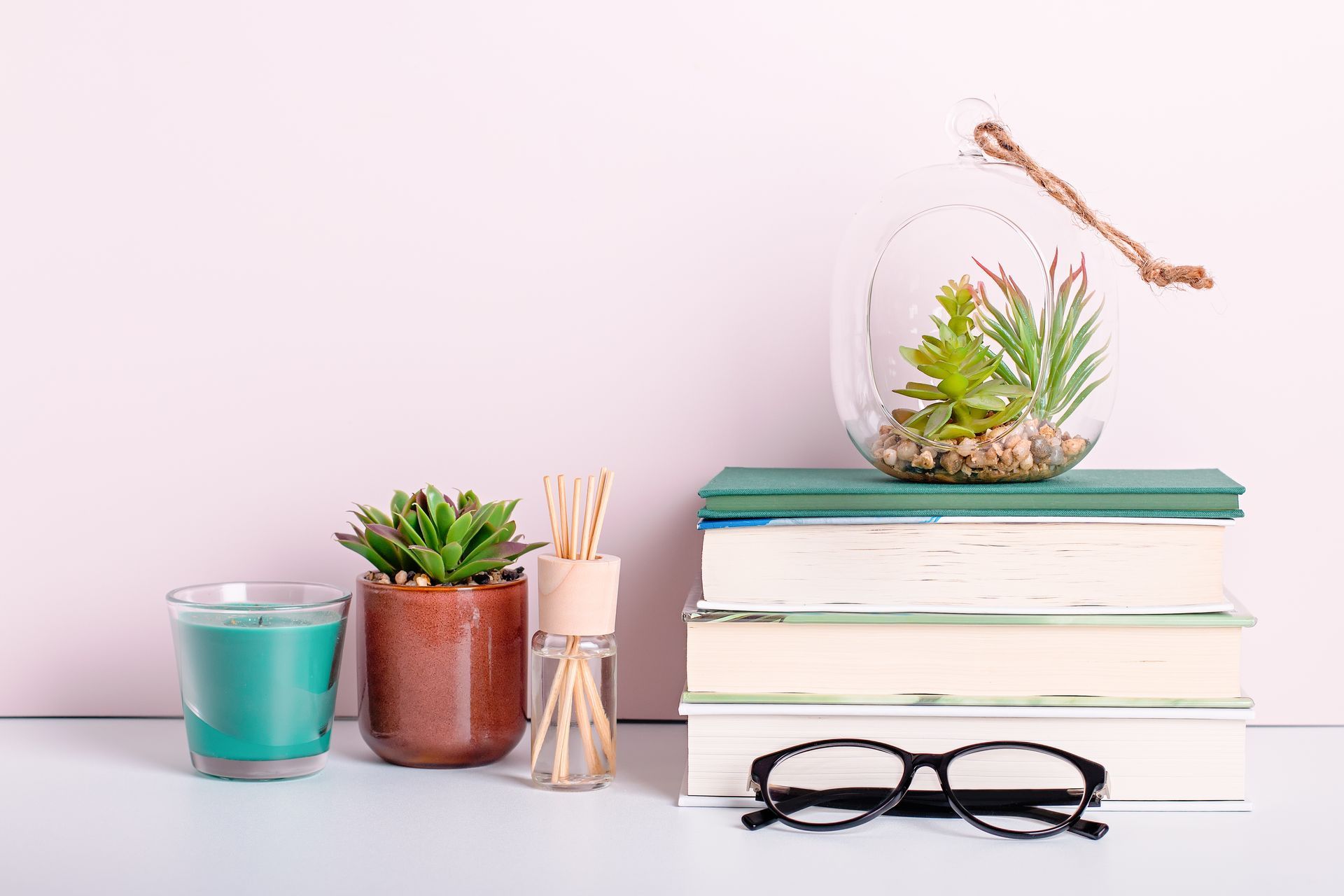 Succulent plants on a desk with books and a pair of glasses.