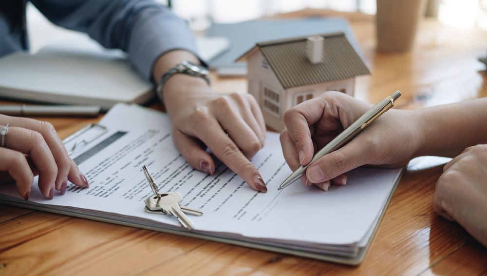 signing an apartment lease with keys on the document