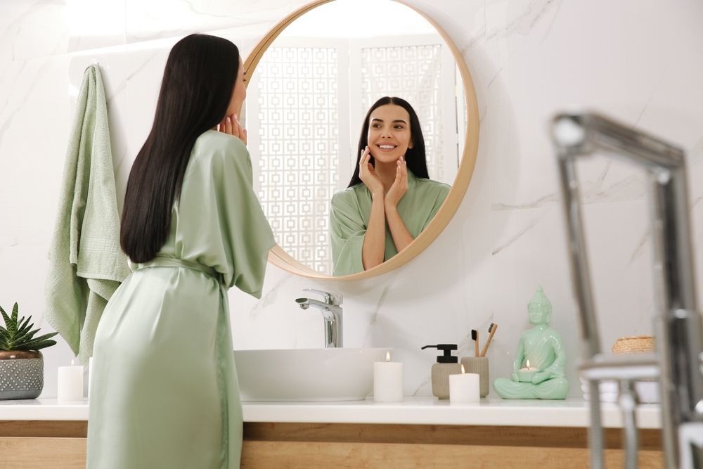 woman looking in mirror in clean apartment bathroom