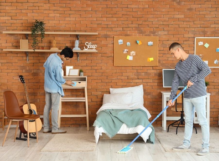 College roommates cleaning their apartment together as part of their cleaning routine