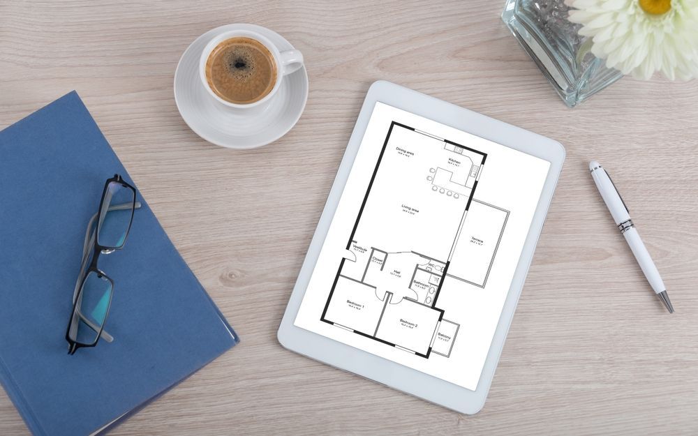 Top view of a desk with a two-bedroom apartment plan concept on a digital tablet
