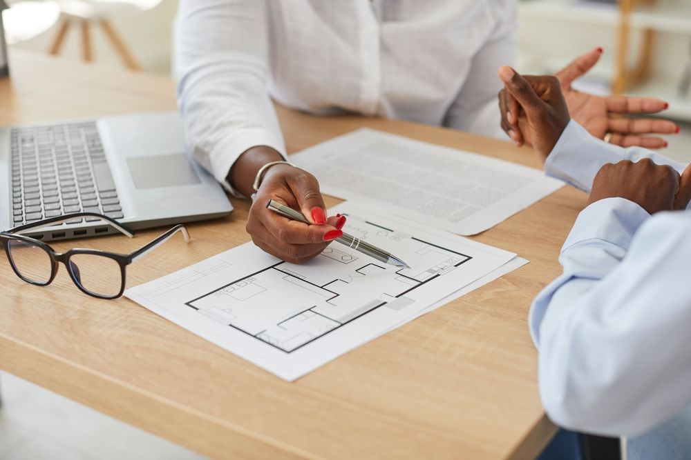 A worker showing someone an apartment floor plan.