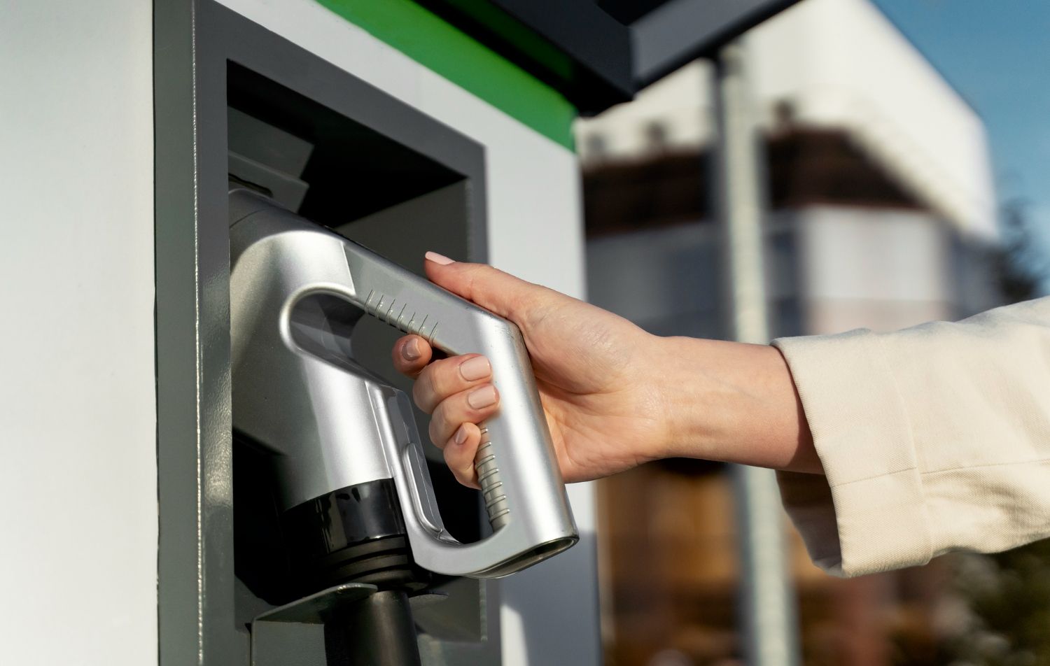 Conectando manualmente um veículo elétrico a uma estação de carregamento em um carregador de rua.