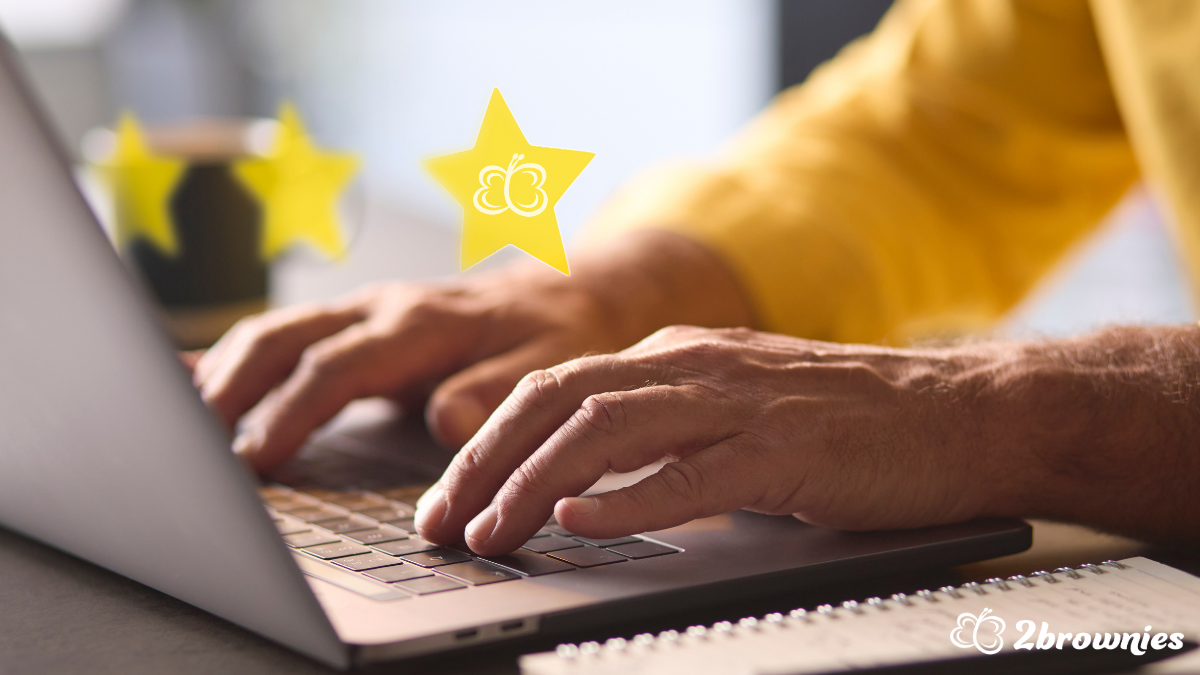 Hands typing on a laptop with yellow stars floating above