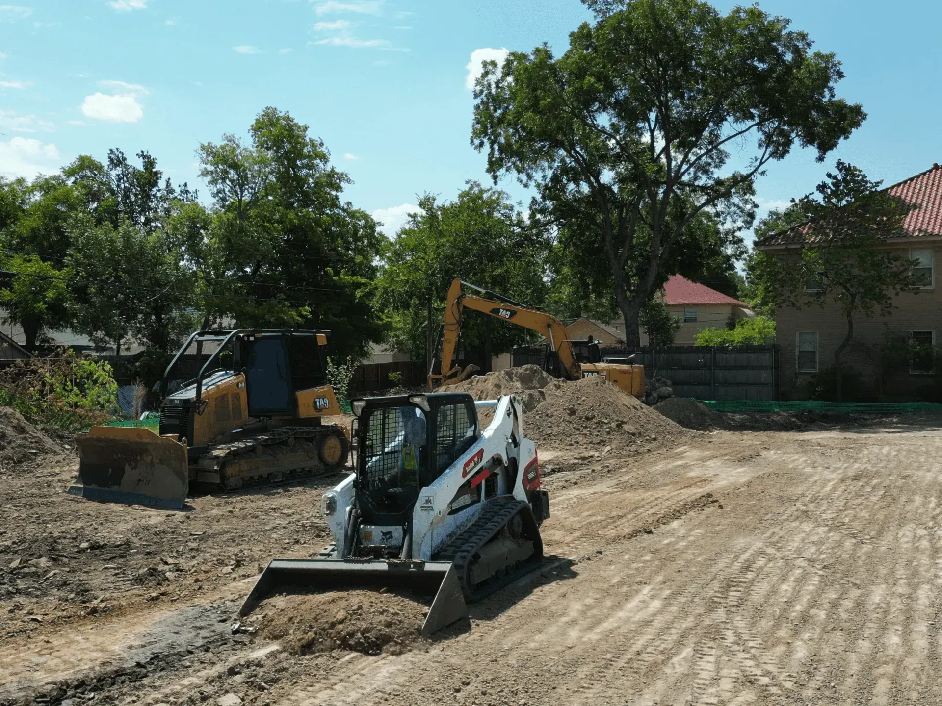 Track loader backfilling dirt on a site prep job in Conroe, Texas.