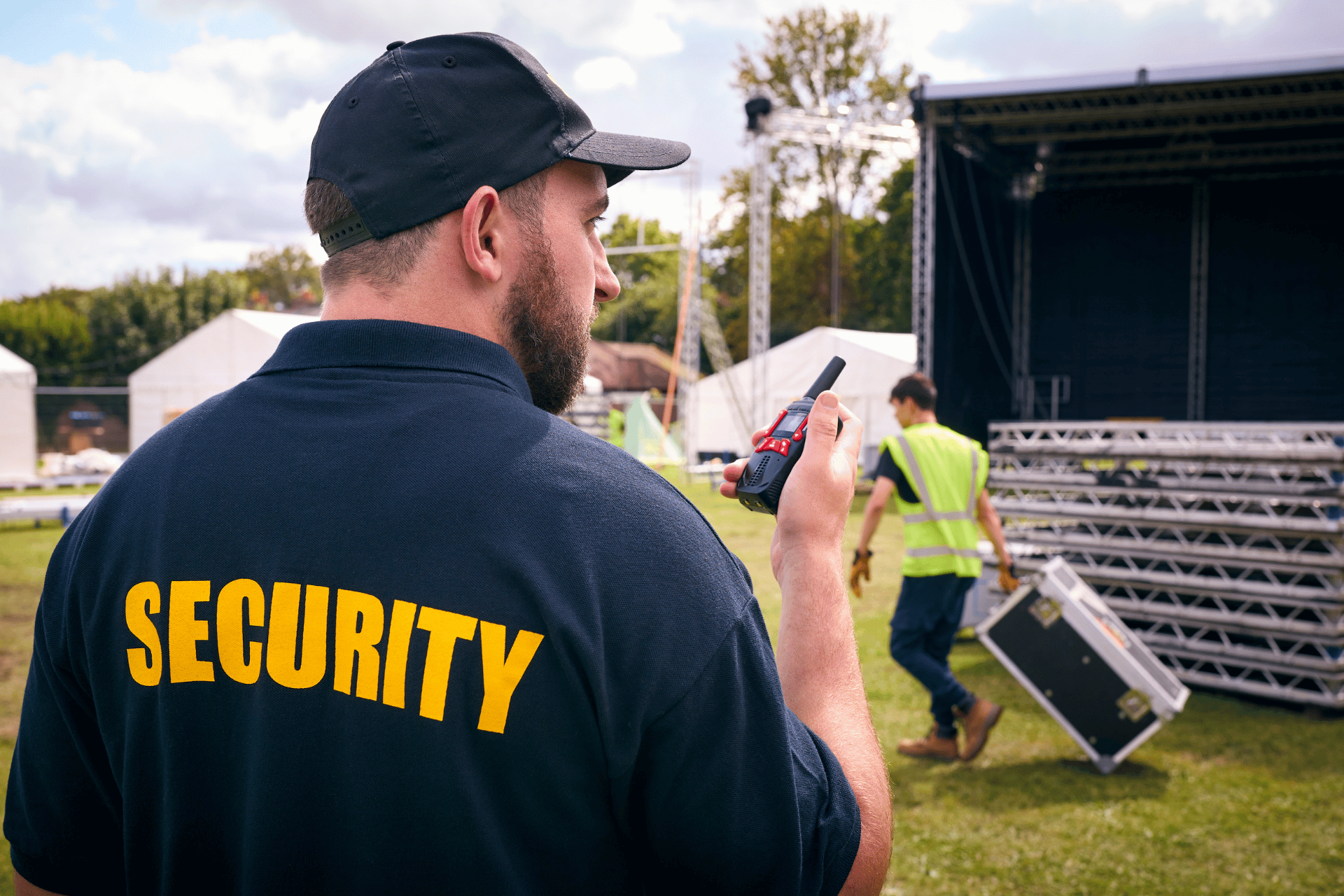 Security guard in a black cap and shirt with yellow 