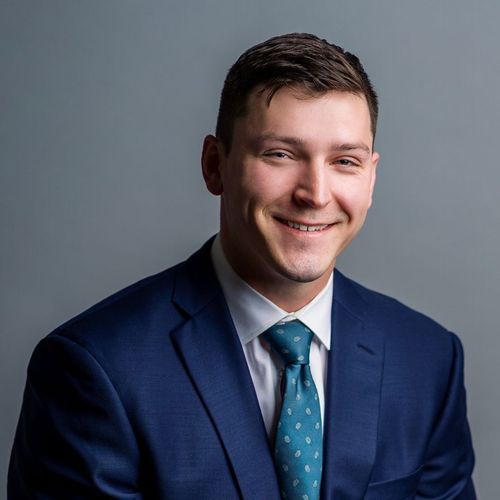 A man in a suit and tie is smiling for the camera.