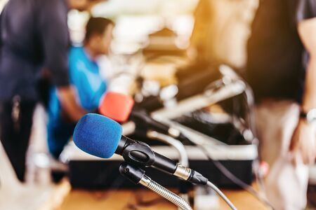 A microphone is sitting on a table in front of a group of people.