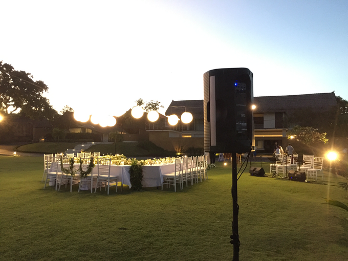A large lawn with tables and chairs set up for a wedding reception