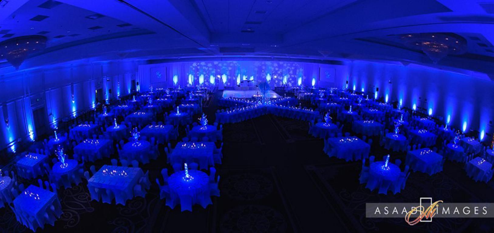 A large room with blue lights on the walls and tables