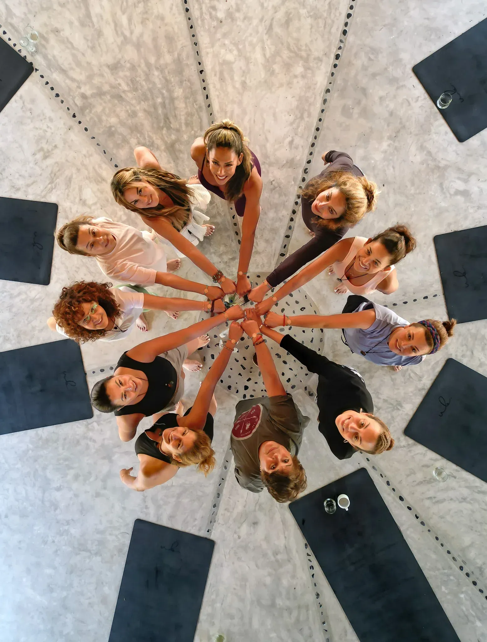 Grupo de mujeres en círculo, con las manos juntas. Vista aérea.  En un estudio moderno y luminoso.
