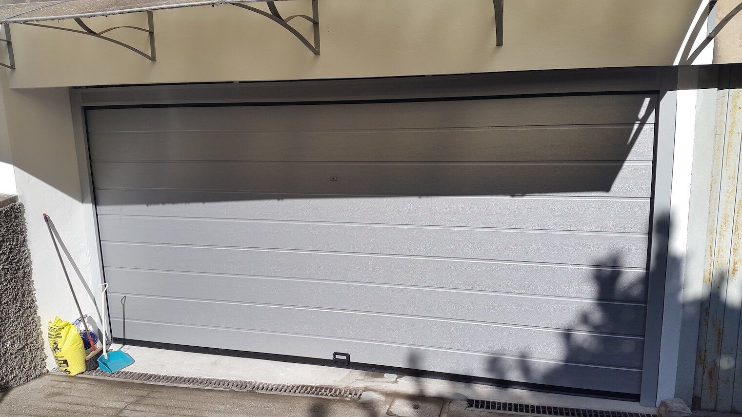 La porta del garage è aperta e c'è una persona in piedi davanti.