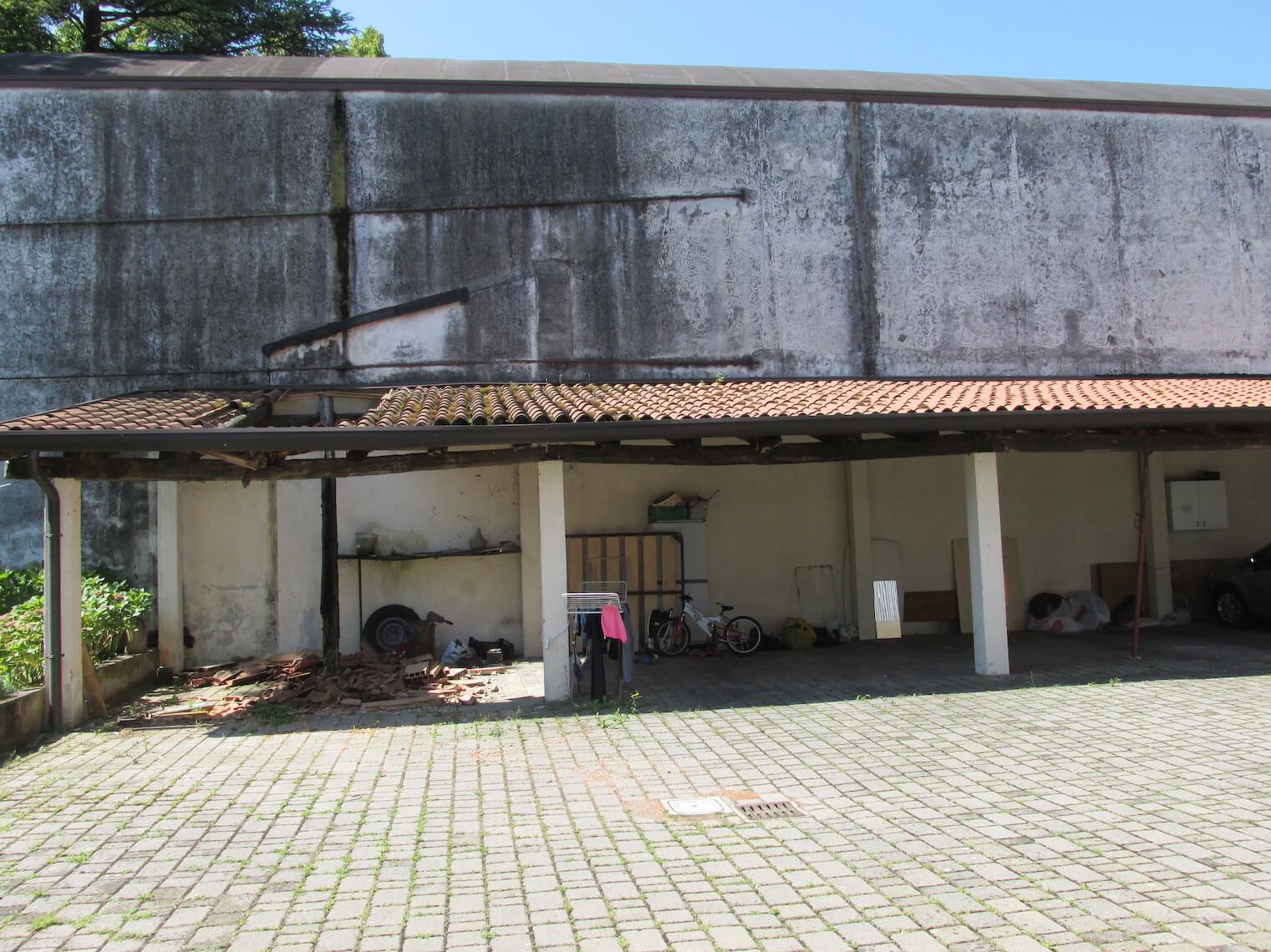 Un vialetto in mattoni che conduce a un edificio con un tetto